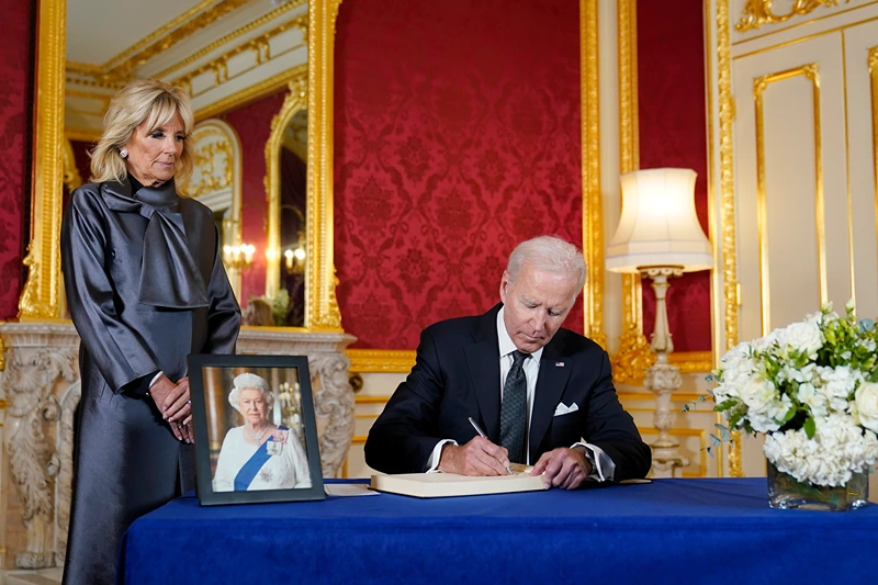 President Joe Biden signs a book of condolence at Lancaster House in London, following the death of Queen Elizabeth II, Sunday, Sept. 18, 2022, as first lady Jill Biden looks on. (AP Photo/Susan Walsh)